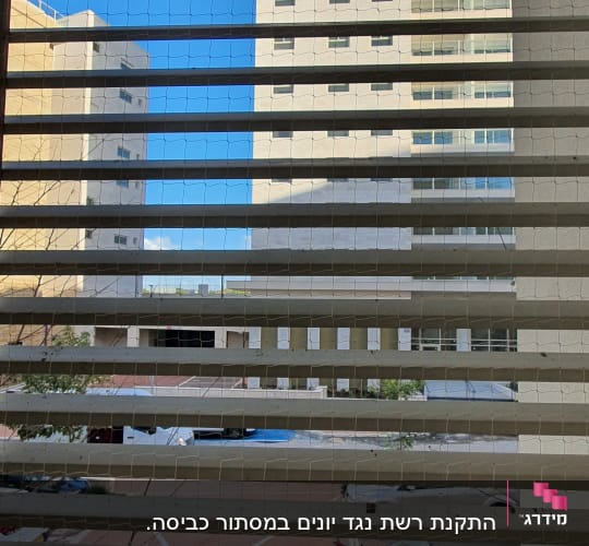 רשת מתוחה על חלון למניעת כניסת יונים